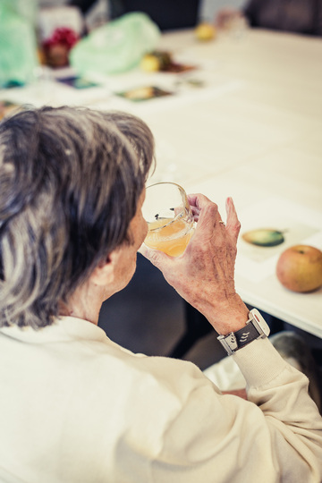 Een bewoner van het woonzorgcentrum ruikt aan peren of appelsap.