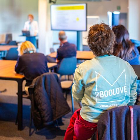 Toeschouwers die naar een spreker luisteren