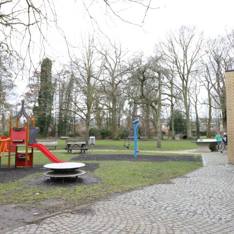 Het speelplein bij wijkhuis Papenhof met een glijbaan, schommel en pingpongtafel