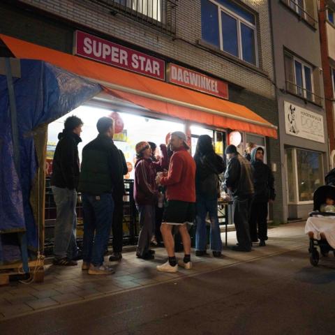 Mensen voor een nachtwinkel in wijk Arsenaal