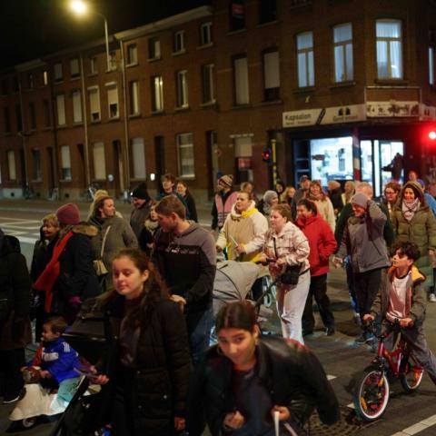 Een groep mensen die de Leuvensesteenweg in wijk Arsenaal oversteken tijdens de Lampionnekestocht