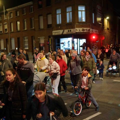Een groep mensen die de Leuvensesteenweg in wijk Arsenaal oversteken tijdens de Lampionnekestocht