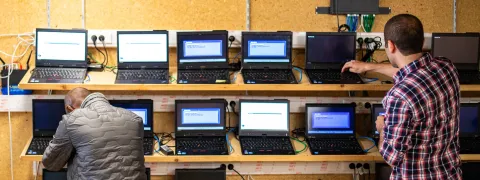 Laptops in een digibankatelier met twee onherkenbare personen