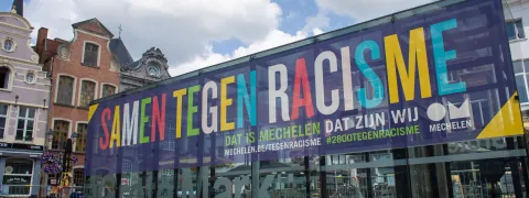 Een grote spandoek op de grote markt met daarop de tekst 'Samen tegen racisme'