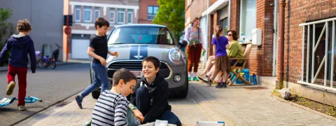 Kinderen spelen op de grond in een speelstraat.