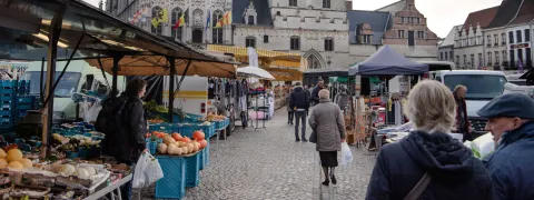 Mensen wandelen tussen de kramen van de zaterdagmarkt
