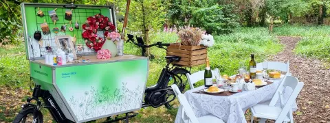 De troostfiets opgesteld bij een koffietafel in een park
