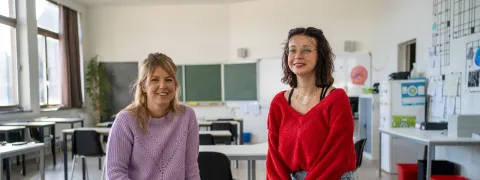 Een leerlingbegeleidster en buddy zitten in de klas.