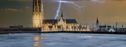 Je ziet een fictieve foto van een blikseminslag op de Sint-Romboutstoren