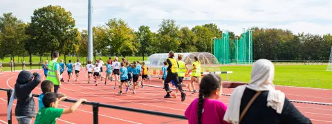 Kinderen lopen tijdens de scholenveldloop in de Nekker.