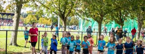 Kinderen lopen tijdens de scholenveldloop in de Nekker.